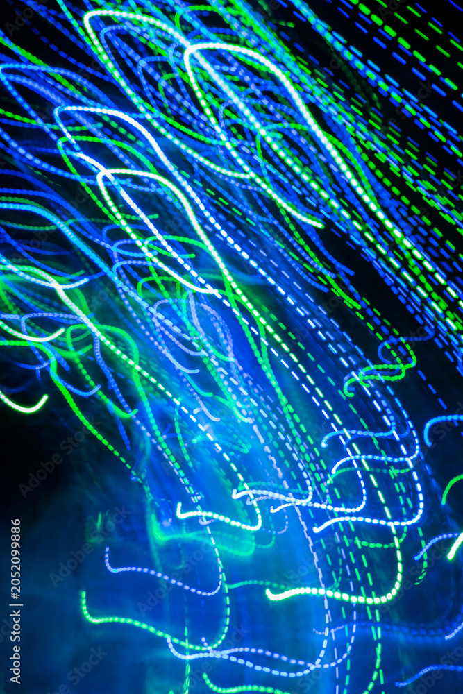 Fototapeta premium Swirling waves of vibrant blue and green lights create a mesmerizing dance in the night