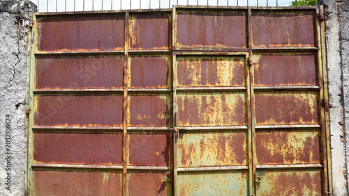 Closed rusty iron gate.Close-up of a closed iron gate covered with rust and weathered texture
