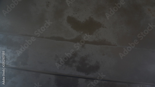 Oil stains on a dirty and dusty wall, Close-up of a dirty wall surface covered with dust and visible oil stains. The rough texture, smudges, and uneven discoloration create a gritty urban and industri