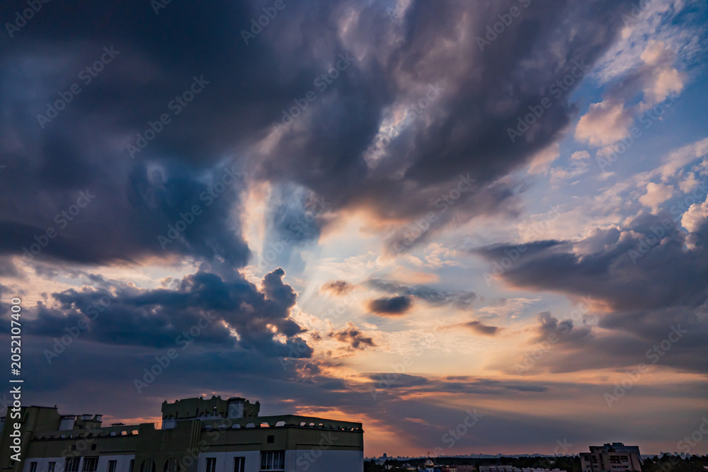 Fototapeta premium Majestic twilight hues dance across the sky over urban rooftops, capturing the day's last light and the promise of night