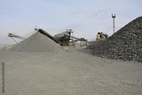 Obraz na plátně Crushed stone pile close up with industrial gravel quarry crushing plant machine