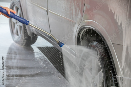 Car washing with a high pressure water jet at an outdoor self-service  car wash station.