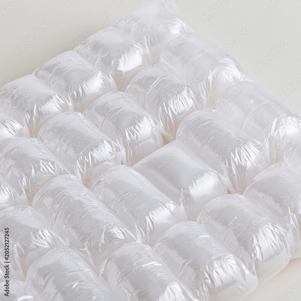 Fototapeta premium A close up view of clear plastic air cushion packaging material lying on a plain white background