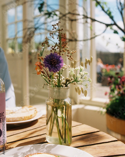 Photography Wildflower bouquet on a sunny cafe table photographed on film