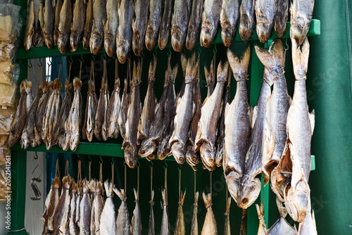 Close up abstract view of traditional Chinese salted dried fish hanging on hooks at outdoor seafood street market in Macau