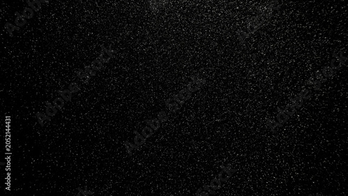 Photography fine sparkling silver glitter texture shimmering over deep black background with