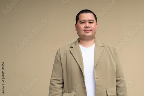 Confident plus size Isan Thai businessman with clean studio background