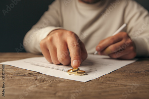 Obraz na płótnie Wedding rings on a wedding contract in the hands of a man