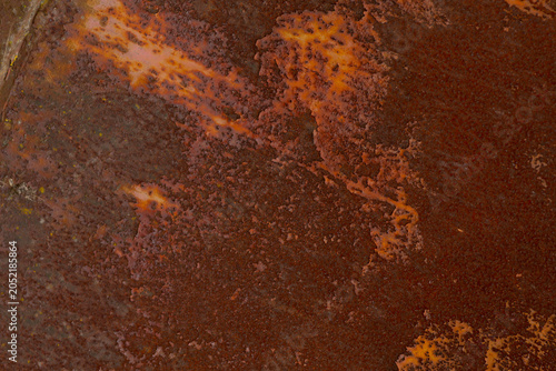 Tableau sur toile Macro photograph of a heavily rusted metal surface revealing flaking paint, orange-brown oxidation, pitting and rough texture