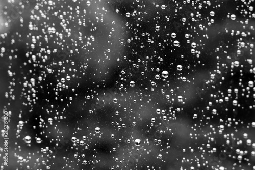 Tableau sur toile Gloomy rain water droplet condensation pattern on wet glass window texture, evok