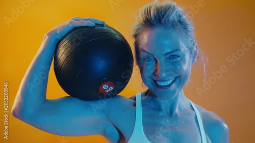 Happy middle-aged woman in a sports bra, covered in sweat