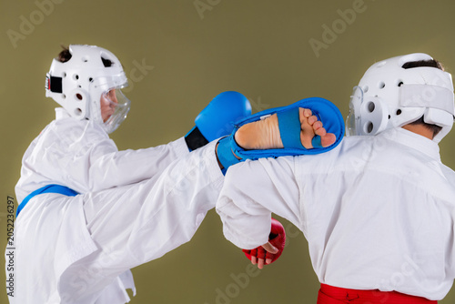 Foto Karate athlete delivers a powerful high kick aimed at the opponent's upper body,