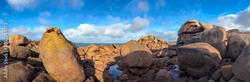 Panel kuchenny z motywem Pink granite boulders scattered along sandy shore in Tregastel, France. Panoramic view