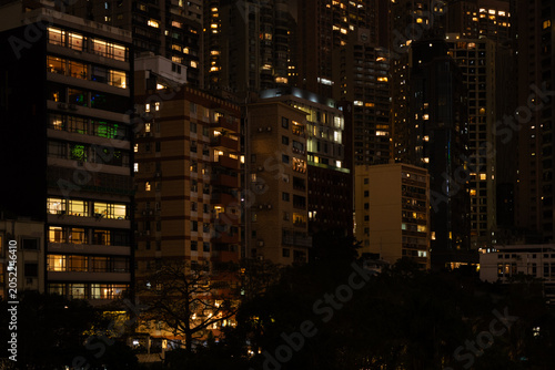 Konstfotografi Densely packed residential buildings of varying heights with lit windows at nigh