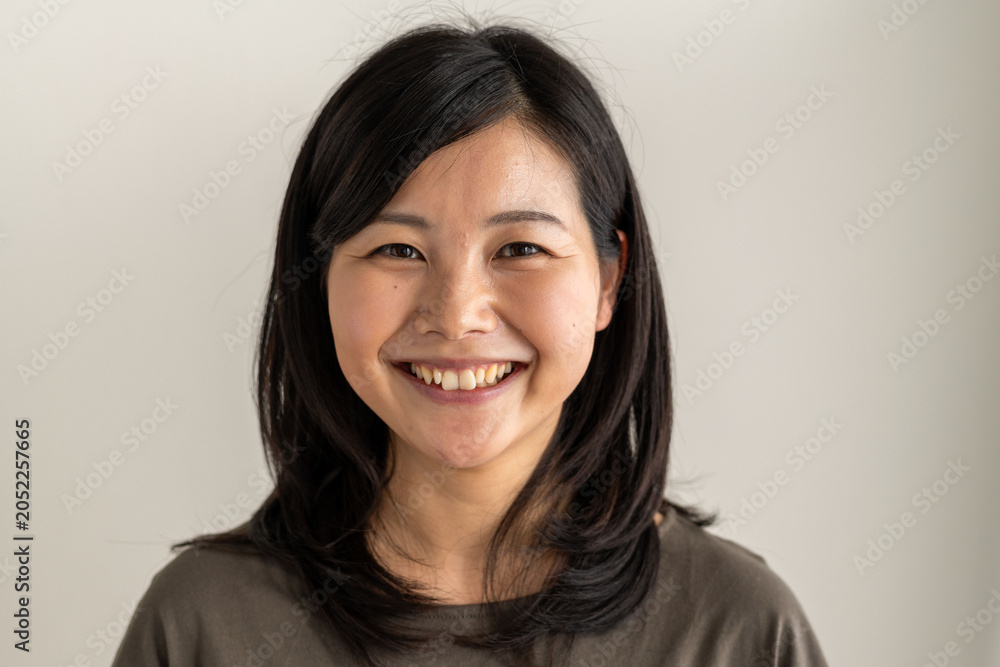 Obraz premium Smiling person with dark hair against a neutral background.