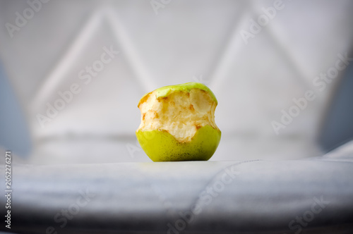 Obraz na plátně Close up shot of an abandoned bitten green apple starting to brown and oxidize o