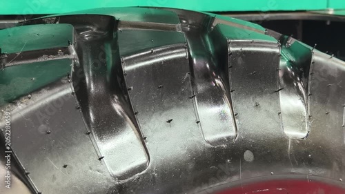 Close-up view of a rugged tire revealing intricate tread patterns and moisture on a construction vehicle's surface