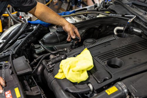 Auto mechanic working in repair shop garage. Vehicle maintenance and inspection service