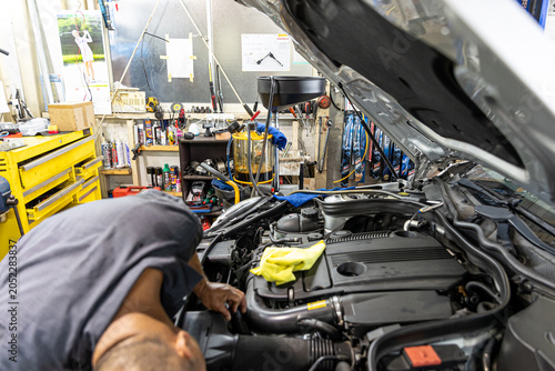 Auto mechanic working in repair shop garage. Vehicle maintenance and inspection service