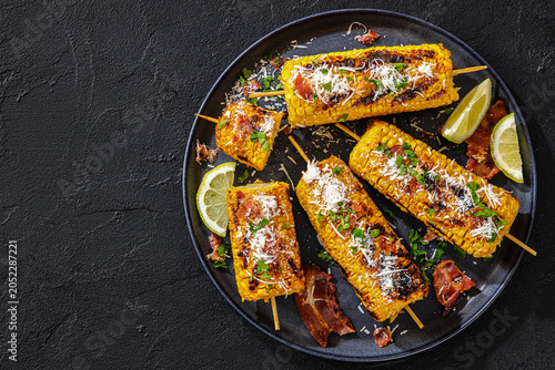 Grilled corn side dish is topped with bacon