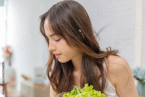 Photography Self-Care:Delicious Salad, Filling the Day with Joy:Image of a young girl looking at a bowl of salad with a satisfied smile in