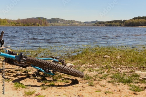 A serene lakeside scene with clear blue water reflecting the sky - Biking at Lake Lipno in Czech Republic