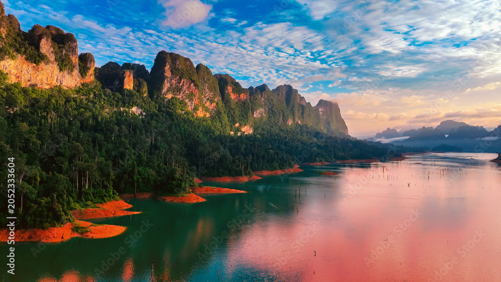 Obraz premium The green area at Khao Sok national park Cheow Lan Dam lake with blue sky background in Surat Thani, Thailand