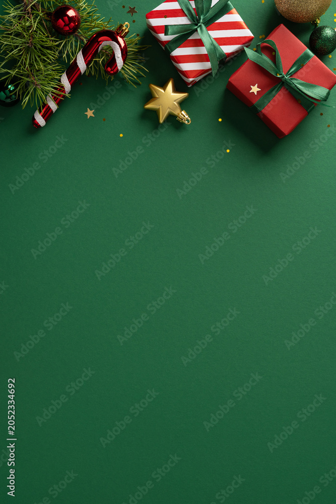 Fototapeta premium Merry Christmas and Happy New Year gifts with ribbon, candy cane and ornaments on vertical green background