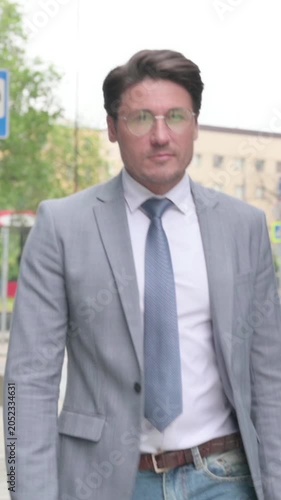 Close up of Middle Aged Businessman Walking in Empty Street, Slow Motion, vertical video