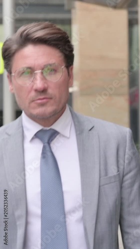 Close up of Middle Aged Businessman Walking on Street, Slow Motion, vertical video