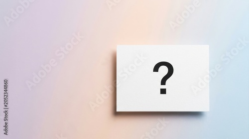 Question mark printed on a white paper card placed on a minimalist background. Concept of FAQ, customer support, inquiry, information search and business communication with generous copy space.