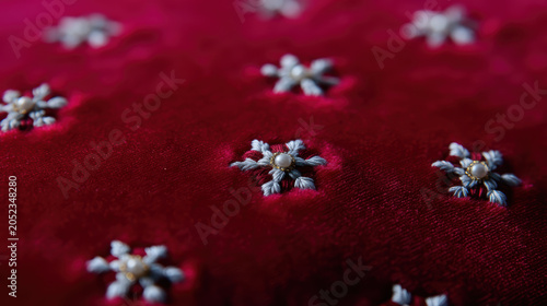 Red velvet embroidered flower fabric texture textile pattern close up detail shot, rich red velvet textile with small