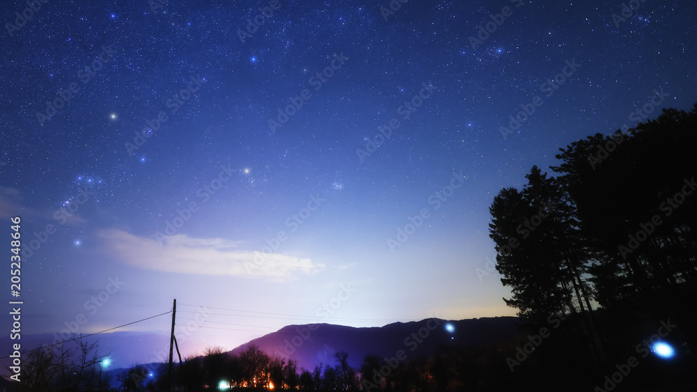 Obraz premium Constellations, zodiacal light and Milky Way stars on a dark countryside skies.