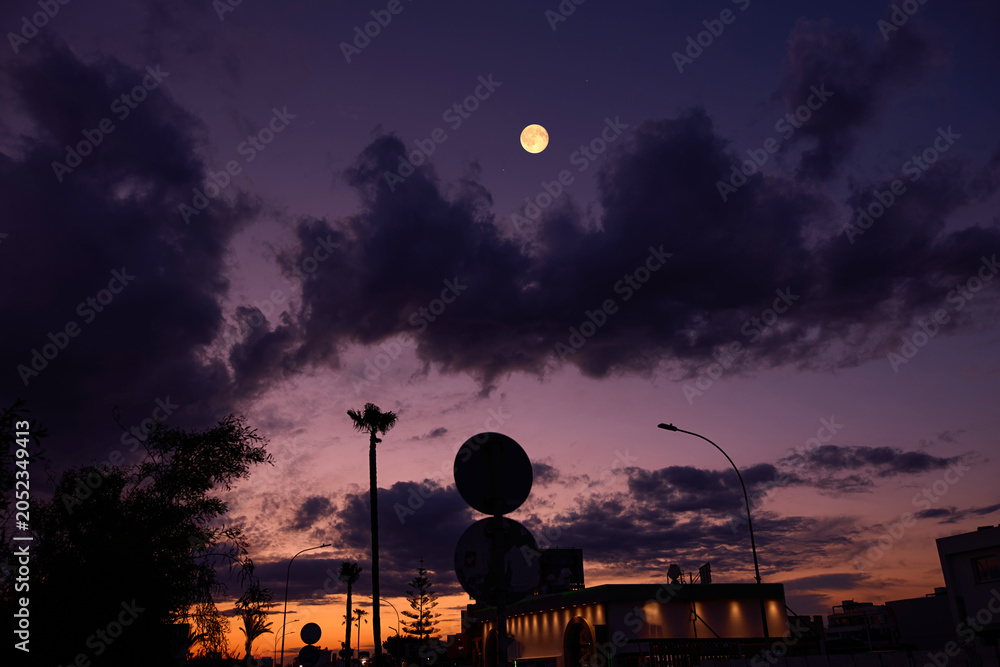 Obraz premium Full Moon with urban silhouettes.