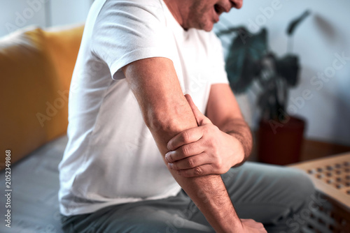 Quadro su tela Man with elbow pain at home.
