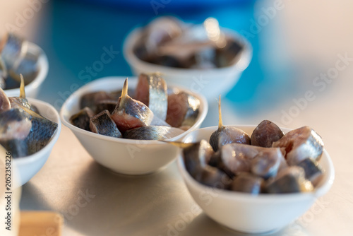 Фотография Small bowls hold fresh sardines, glistening with brine