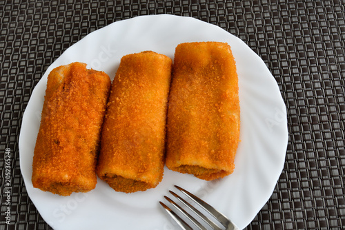 Three orange croquettes on a plate