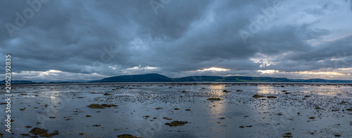 Tableau sur toile nverness Firth at Low Tide with Dramatic Stormy Sky and Distant Hills, Scotland