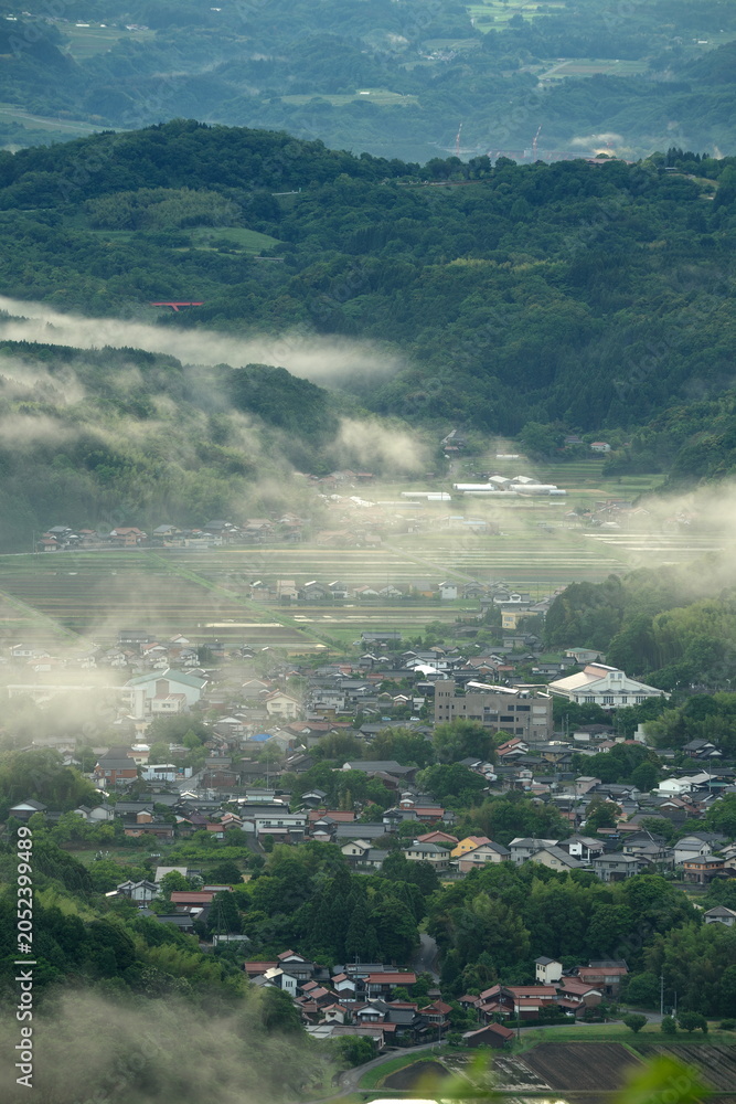 Obraz premium 鳥取県米子市で水田が広がる春の山間の住宅地