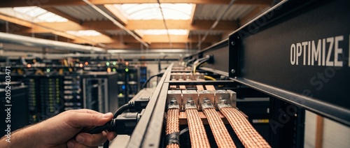Data center server power cable connection by technician hand plugging system in server room racks for cloud network infrastructure optimization, maintenance, hardware support, and database operations.
