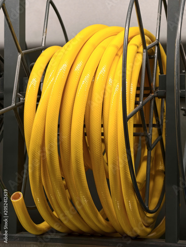 Foto Yellow flexible hose arranged in a circular coil is shown on store shelving in a