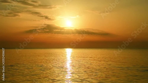 Golden sunset over calm sea, sunlight reflecting on peaceful water, warm glow on horizon, tranquil ocean scene with serene sky, natural beauty and relaxing coastal view