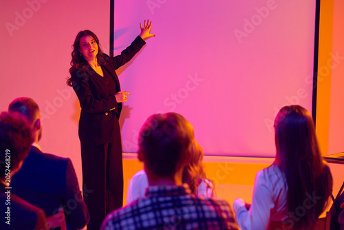 Принти на полотні Presenter explaining ideas beside projection screen to seated audience