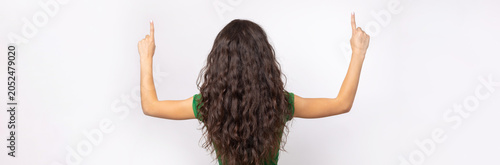 Happy young caucasian female in a shirt pointing fingers away