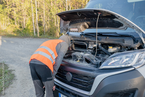 Картината върху платно roadside assistance worker inspecting engine compartment of broken delivery van
