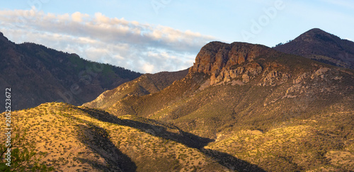 Just as dawn breaks the hills, valleys and cliffs on the Huachuca mountains bask in a warm glow