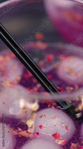 A summer alcoholic purple drink served with ice during a romantic date between a man and a woman. A close-up of lemonade for freshness.