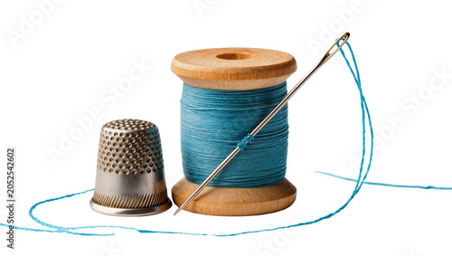 Foto Wooden spool of blue thread with needle and thimble