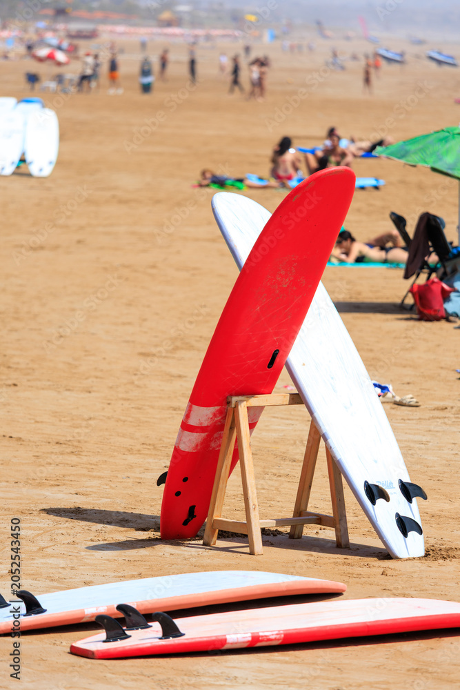 Fototapeta premium two red surfing boards standing on the beach in Taghazout, Morocco
