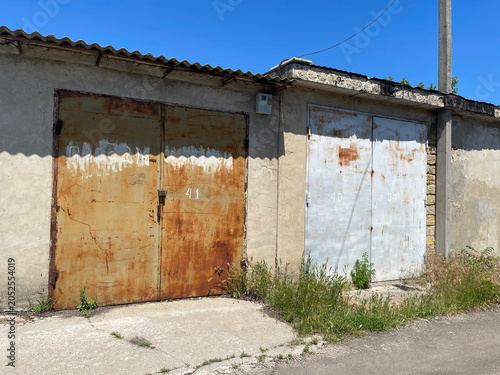 Row of Garages Along Asphalt Road Under Clear Blue Sky on Sunny Day